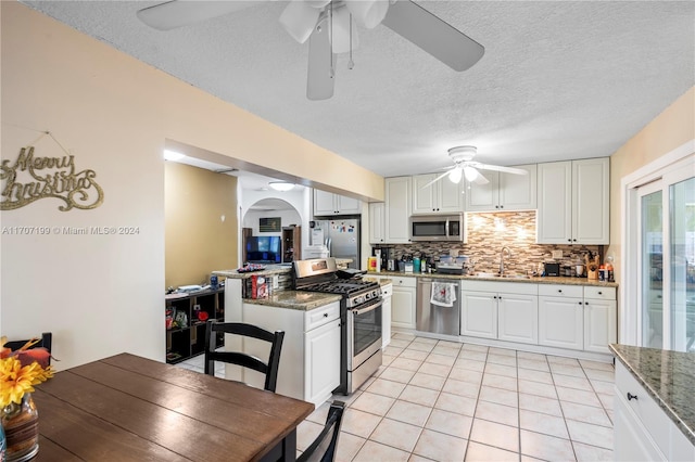 kitchen featuring dark stone countertops, sink, white cabinets, and stainless steel appliances