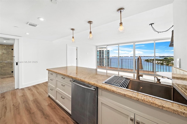 kitchen with light stone counters, a water view, visible vents, hanging light fixtures, and dishwasher