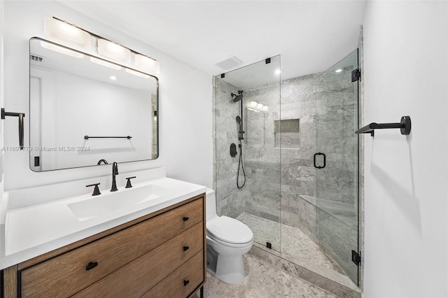 bathroom with vanity, an enclosed shower, and toilet