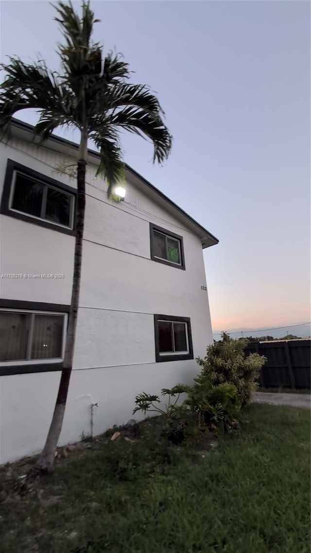 property exterior at dusk featuring a yard