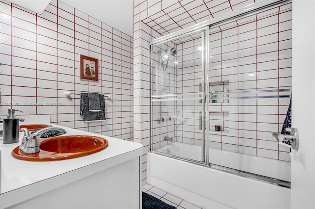 bathroom featuring sink, enclosed tub / shower combo, and tile walls