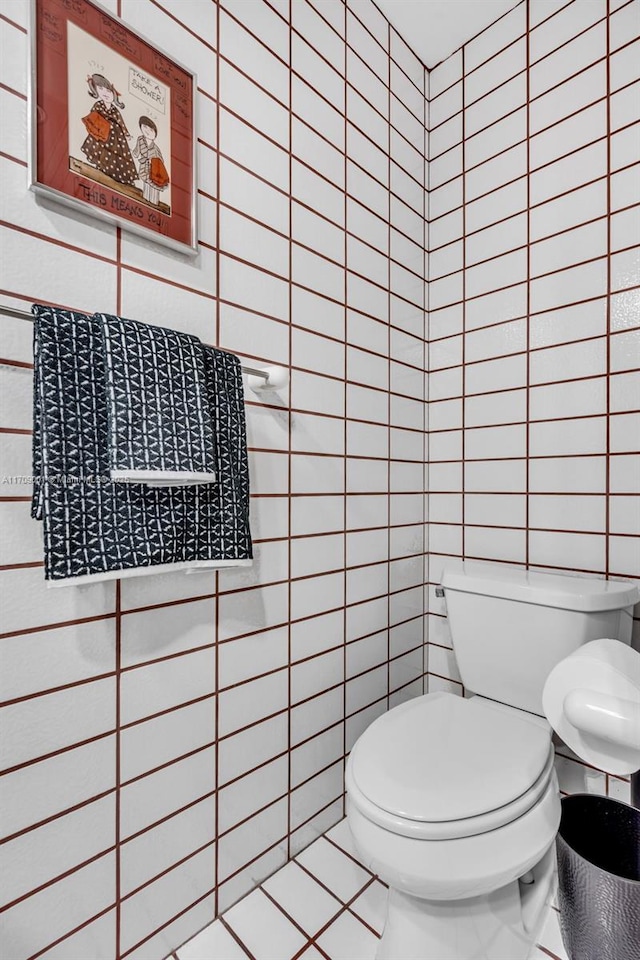 bathroom featuring tile patterned floors, tile walls, and toilet