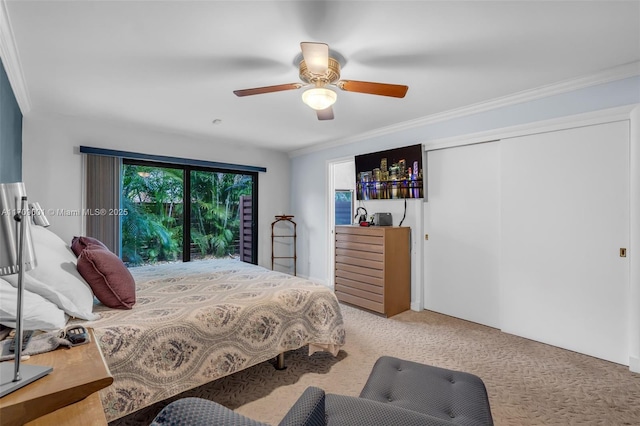 carpeted bedroom featuring ceiling fan, a closet, and crown molding