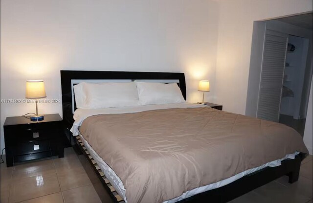 tiled bedroom featuring a closet