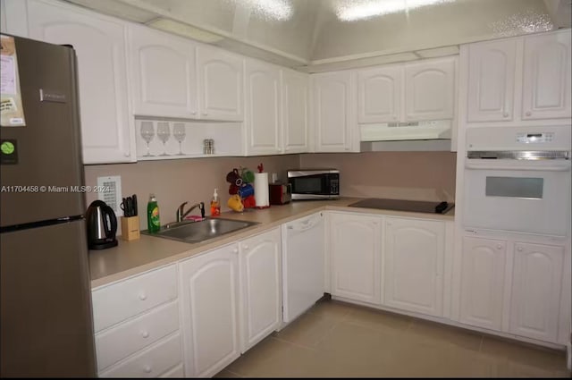 kitchen featuring white cabinets, sink, light tile patterned floors, and stainless steel appliances