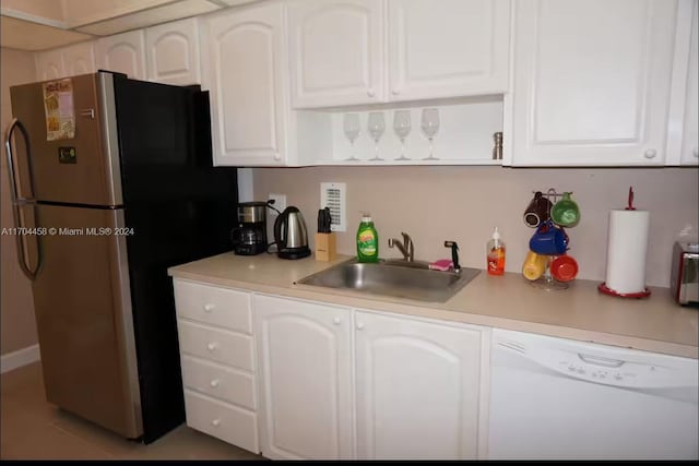 kitchen with stainless steel fridge, white dishwasher, sink, white cabinetry, and light tile patterned flooring