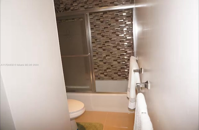 bathroom with shower / bath combination with glass door, tile patterned floors, and toilet