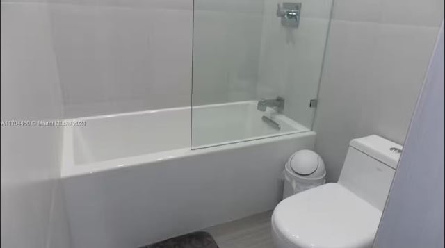 bathroom featuring shower / bathing tub combination and toilet