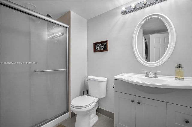 bathroom with tile patterned flooring, vanity, toilet, and walk in shower