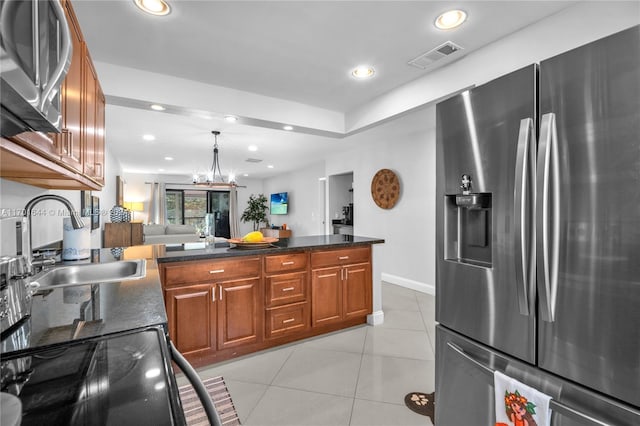 kitchen with appliances with stainless steel finishes, sink, an inviting chandelier, hanging light fixtures, and light tile patterned flooring