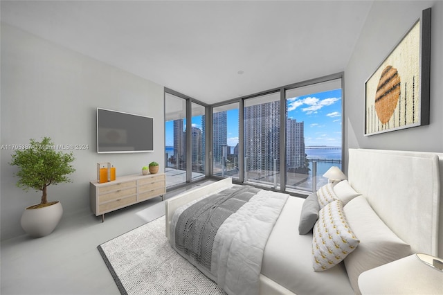 bedroom featuring a wall of windows, access to outside, and concrete floors