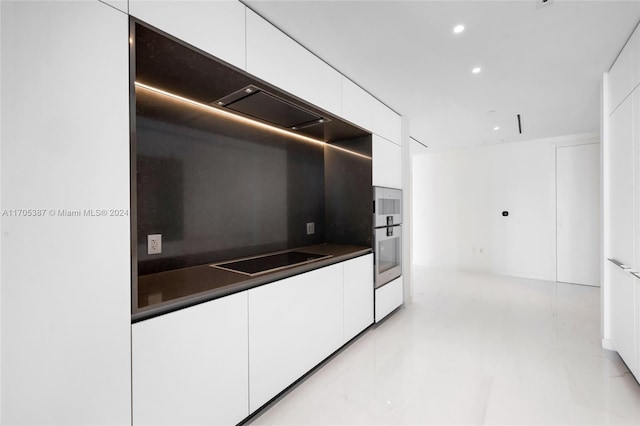 kitchen featuring black electric cooktop and white cabinetry