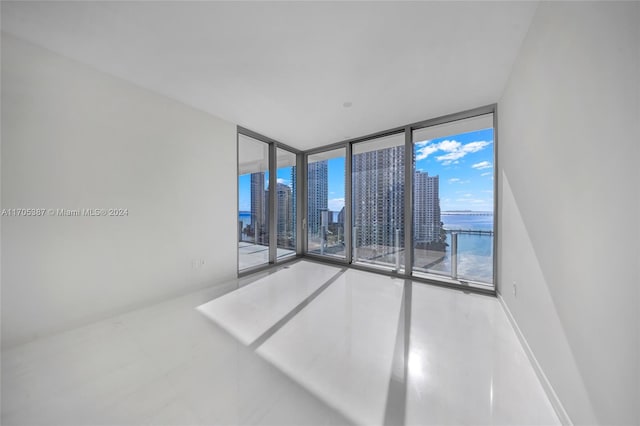 unfurnished room with a water view and floor to ceiling windows