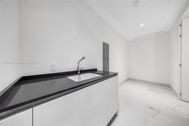 interior space featuring white cabinetry and sink