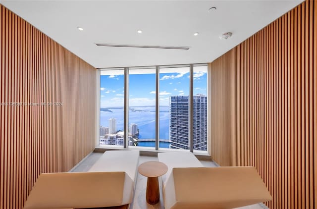 interior space featuring wood walls, floor to ceiling windows, and a water view