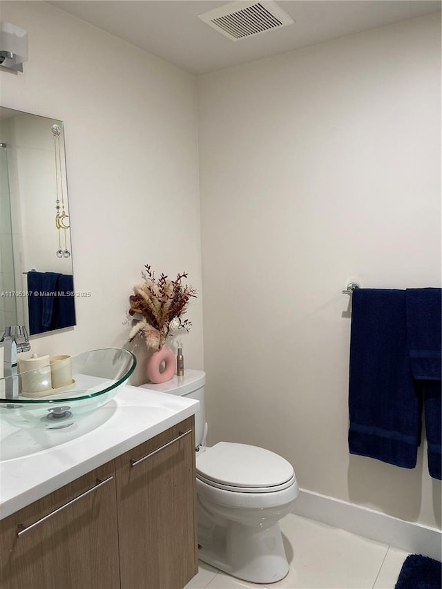 bathroom featuring toilet, vanity, and tile patterned flooring