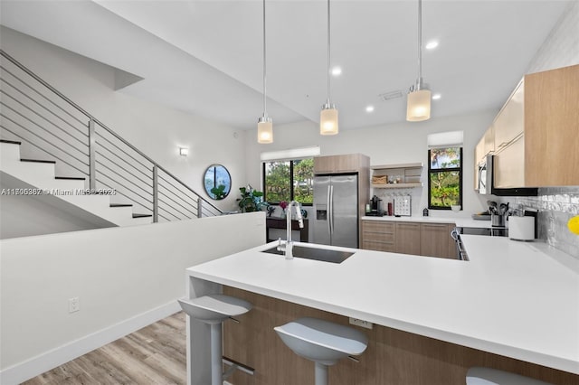 kitchen featuring stainless steel fridge with ice dispenser, tasteful backsplash, hanging light fixtures, and electric stove