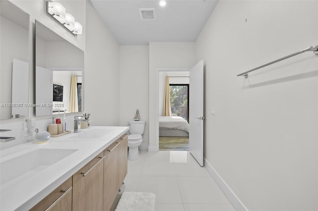 bathroom featuring toilet, vanity, and tile patterned flooring