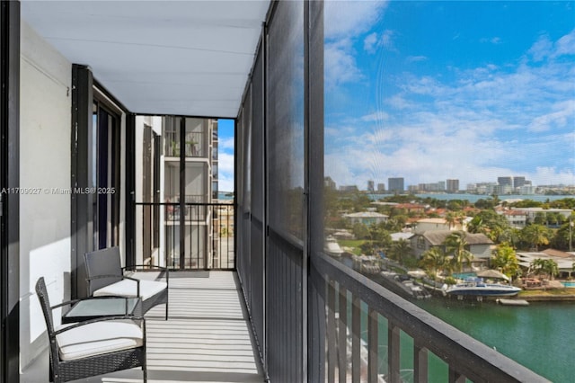 balcony featuring a water view and a city view