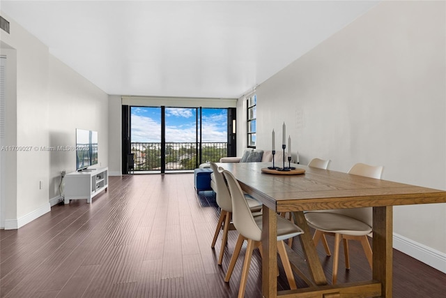 dining room featuring floor to ceiling windows, visible vents, baseboards, and wood finished floors