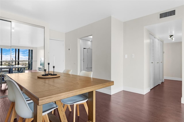 dining space featuring baseboards, visible vents, and wood finished floors