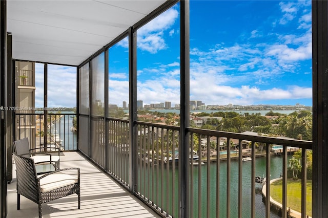 unfurnished sunroom with a water view and a city view