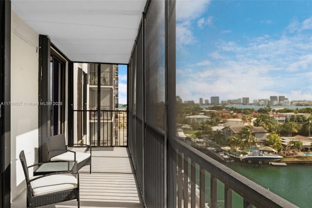 balcony featuring a water view and a city view