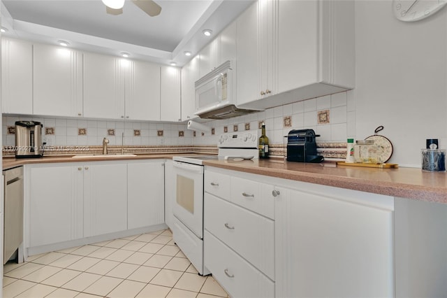 kitchen featuring light tile patterned floors, tasteful backsplash, white cabinetry, a sink, and white appliances