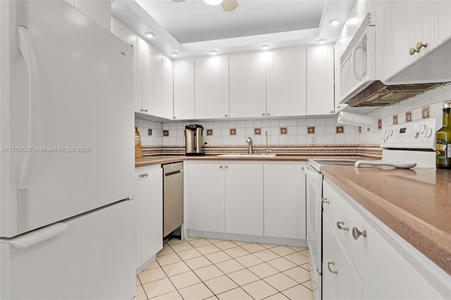 kitchen featuring white appliances, white cabinetry, backsplash, and a sink