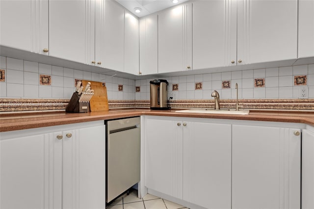 kitchen featuring light tile patterned floors, tasteful backsplash, white cabinets, and a sink