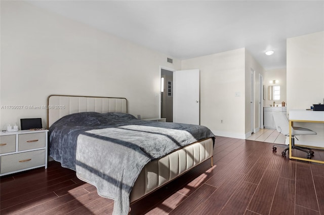 bedroom featuring wood tiled floor, visible vents, and baseboards