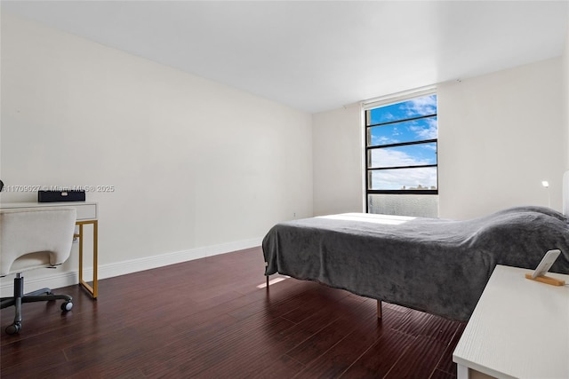 bedroom featuring baseboards and wood finished floors