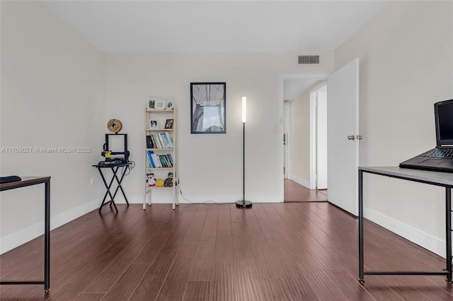 interior space with baseboards, visible vents, and wood finished floors