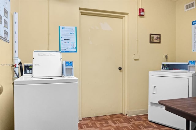 community laundry room featuring visible vents and washer and clothes dryer