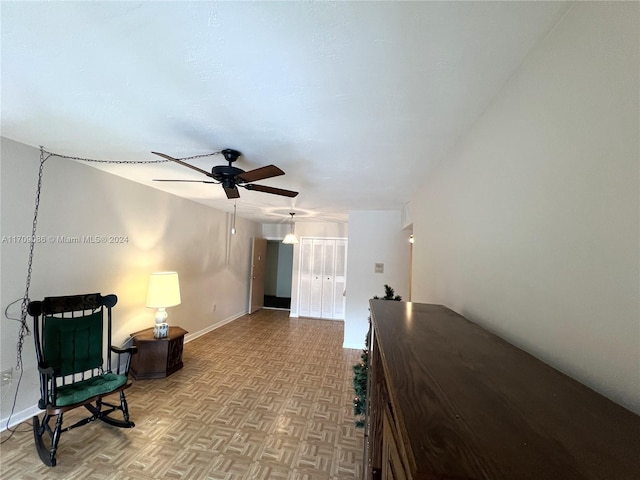 sitting room with ceiling fan and light parquet floors