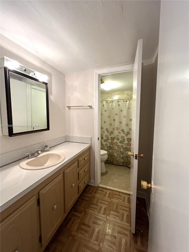 bathroom featuring a shower with curtain, vanity, toilet, and parquet floors