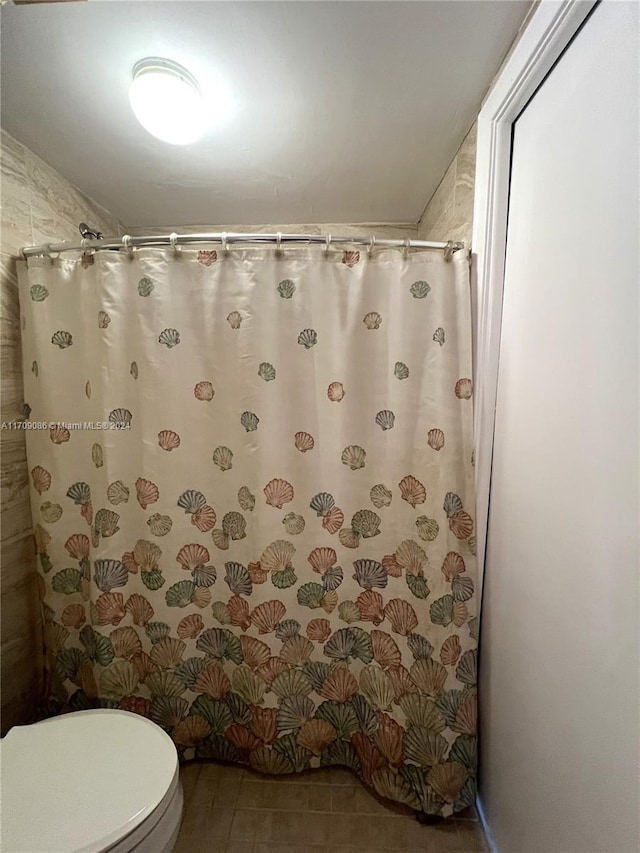 bathroom featuring tile patterned floors, a shower with curtain, and toilet