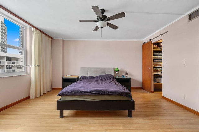 bedroom featuring ceiling fan, ornamental molding, and light hardwood / wood-style flooring