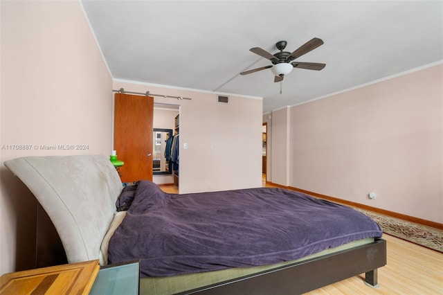 bedroom with hardwood / wood-style floors, ceiling fan, and crown molding