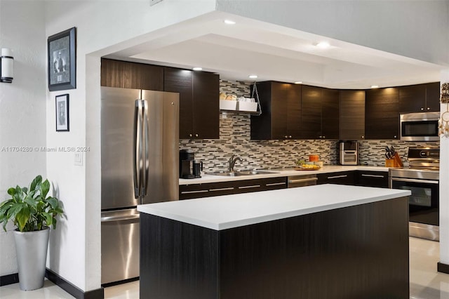 kitchen with a center island, backsplash, sink, appliances with stainless steel finishes, and dark brown cabinetry