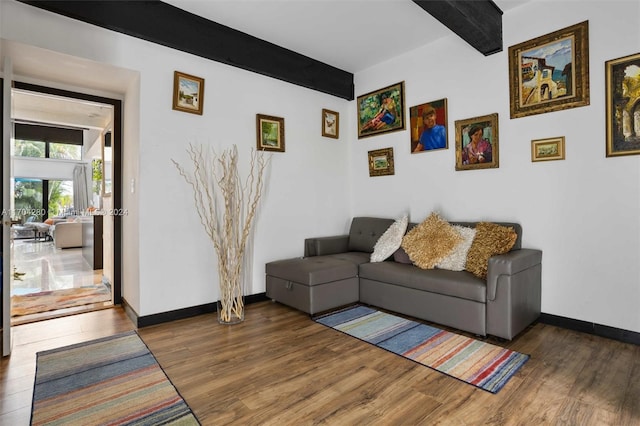 living room with beamed ceiling and dark wood-type flooring