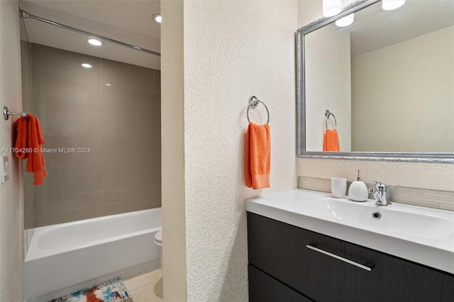 full bathroom featuring toilet, vanity, and tiled shower / bath combo