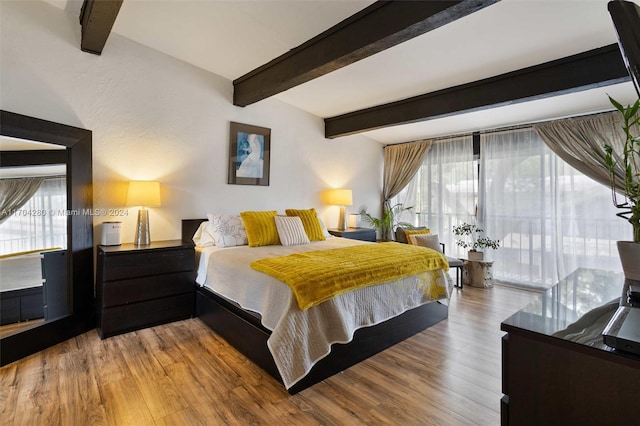 bedroom featuring wood-type flooring and beam ceiling