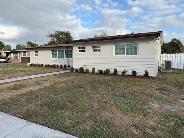 ranch-style home with cooling unit and a front yard