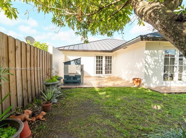 back of house featuring french doors, a patio, and a lawn