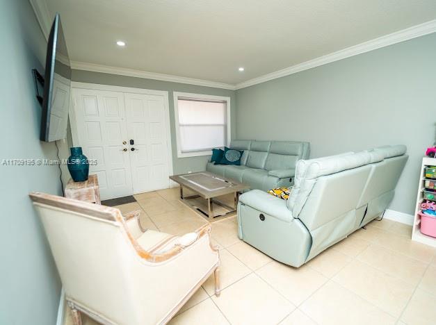 living room featuring crown molding and light tile patterned floors