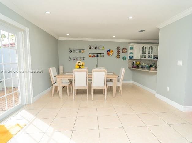 dining space featuring light tile patterned floors and crown molding