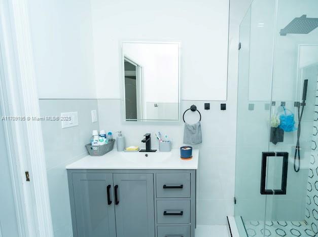 bathroom featuring vanity and a shower with door