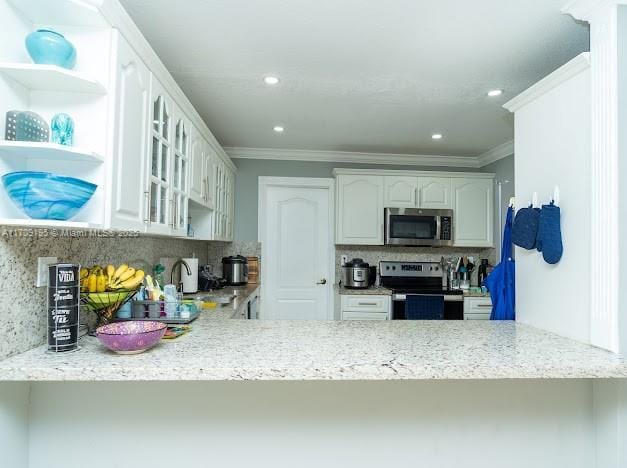 kitchen featuring crown molding, light stone counters, appliances with stainless steel finishes, decorative backsplash, and white cabinets