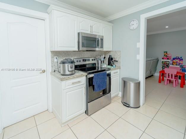 kitchen featuring crown molding, appliances with stainless steel finishes, tasteful backsplash, and white cabinets